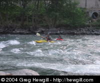 A kayaker with somebody doing "hydrospeed".
